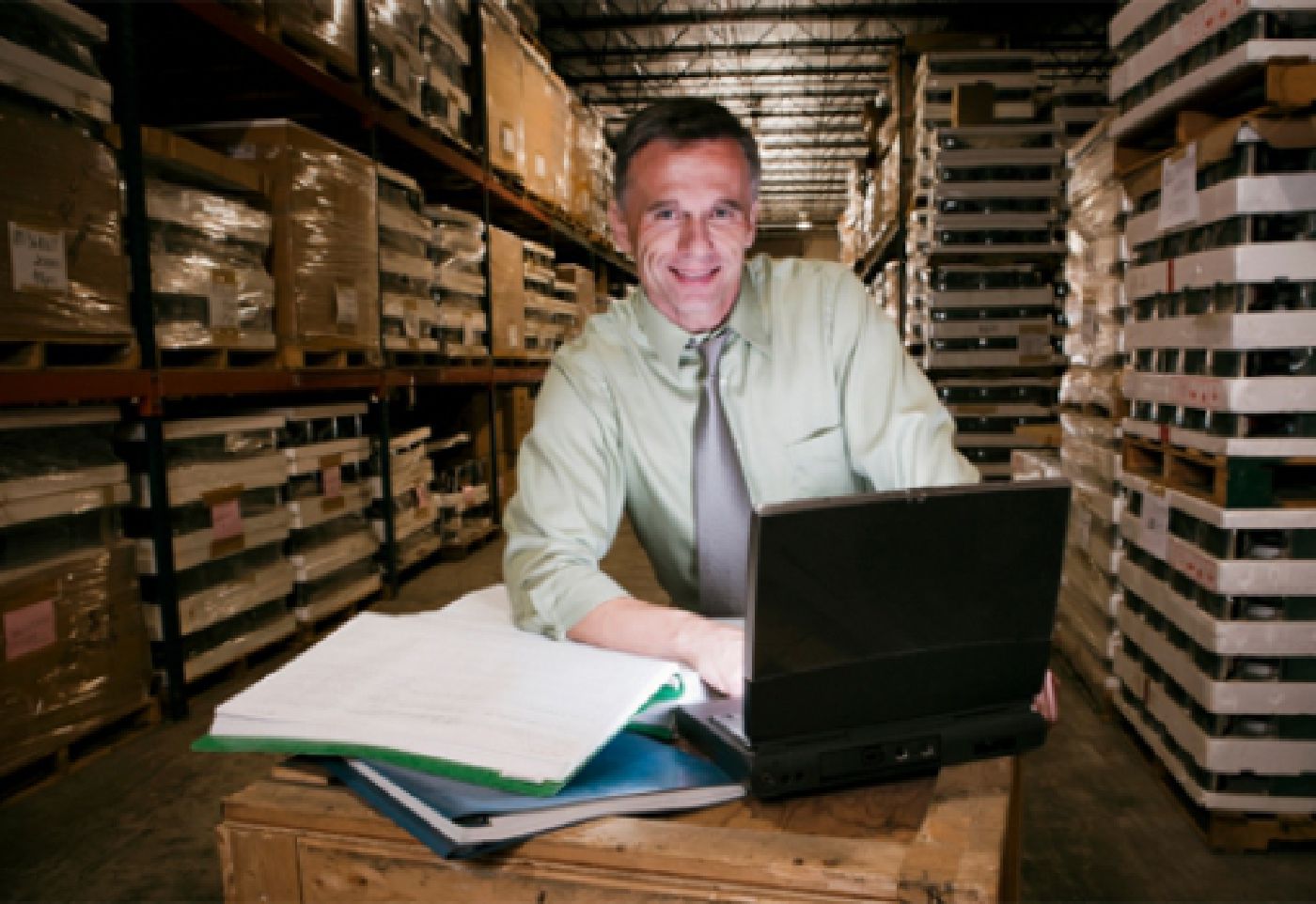 Manager optimizing profits Man optimizing profits on spreadsheet in warehouse